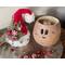 This image shows the Christmas elf hat sitting next to the carved elf gourd. Red and silver jingle bells lay next to the gourd display.